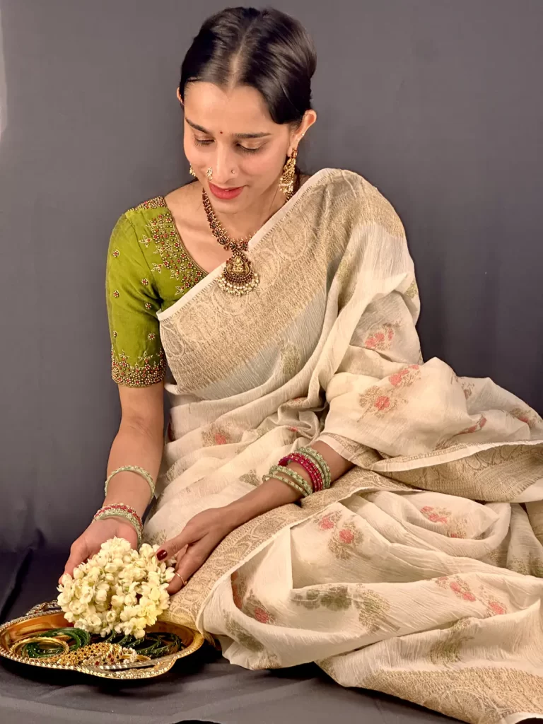 Close-up of model wearing Ivory Crushed Banarasi Saree with antique gold border and green blouse