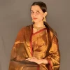 Close portrait showing the golden saree and red border