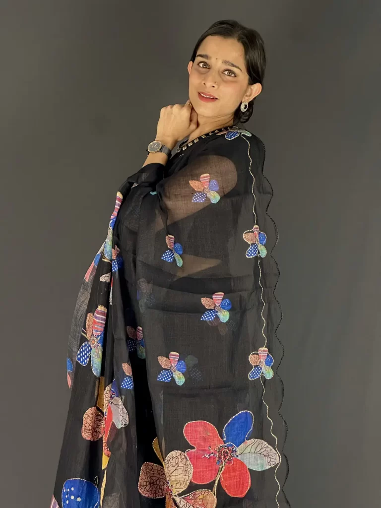 Black linen saree with multicolour floral print and scalloped zari-trim border, front view