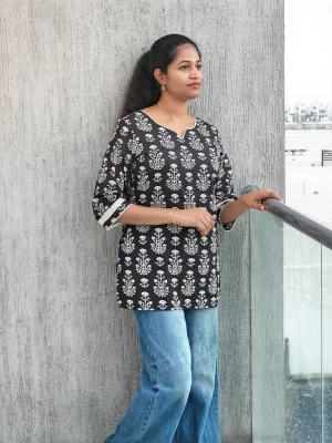 Black floral handblock cotton top with white motifs, three-quarter portrait view