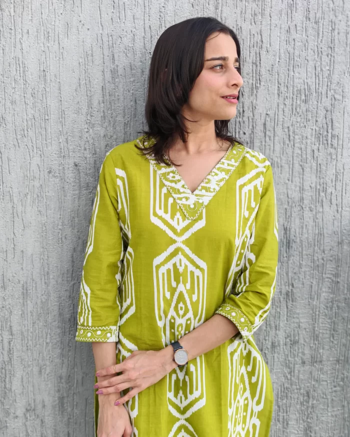 Close front view of lime green Ikat printed co-ord set showing neckline and sleeve trim