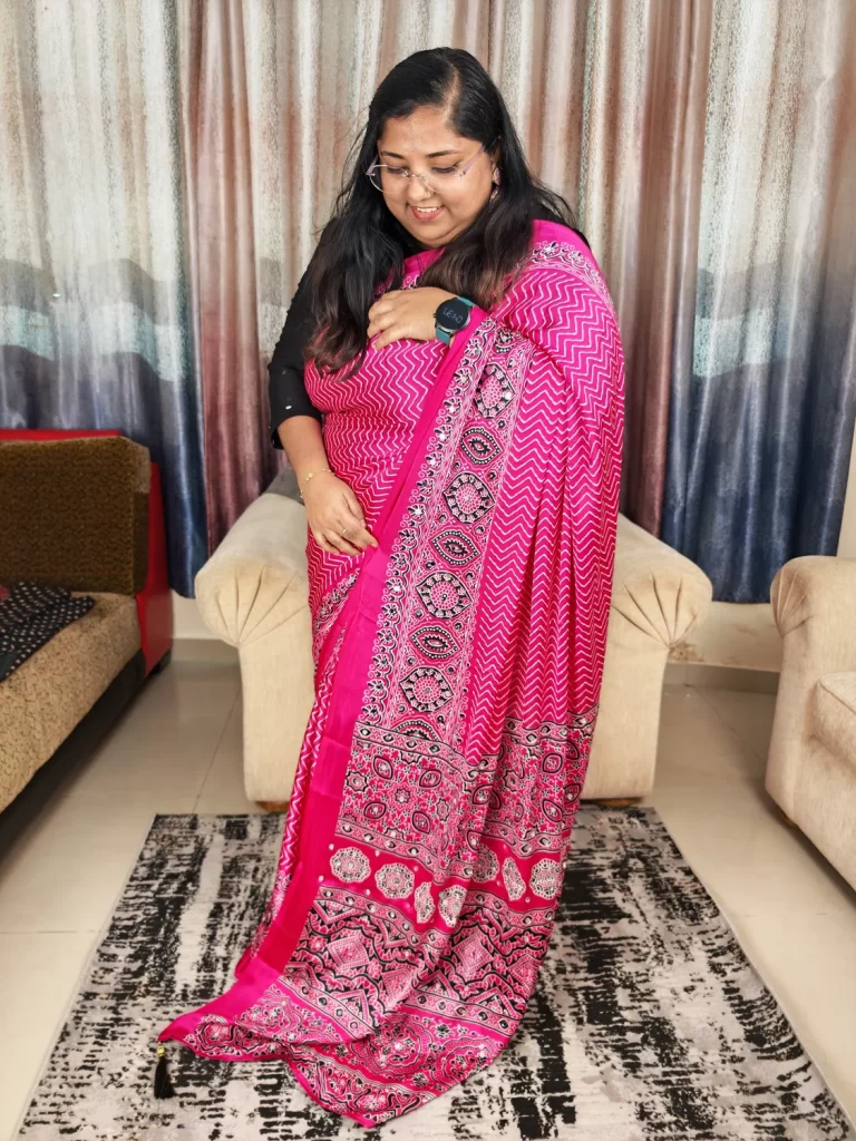 Rani pink Ajrakh modal satin silk saree with chevron print and ornate pallu, draped side view