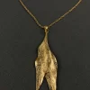 Close-up of the textured double-leaf pendant on the Dual Leaf Neck Chain