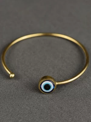 Evil Eye Open Bangle with a classic blue eye motif on a slim gold-toned band