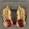 Fern Leaf Drop Earrings with gold-toned fronds and ruby-coloured round stones