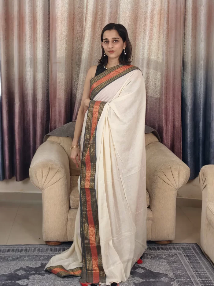 Offwhite Mulcotton Saree with Black & Orange Border (7) Straight-on view of Off-White Mul Cotton Saree showing the black and orange border and front pleats