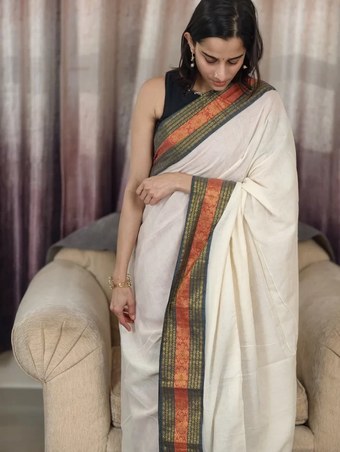 Offwhite Mulcotton Saree with Black & Orange Border (9) Upper-body view of Off-White Mul Cotton Saree highlighting the black blouse and woven border