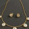 PEARL ARC NECK PIECE SET Pearl Arc Neck Piece Set with spaced pearl-like stones and matching studs