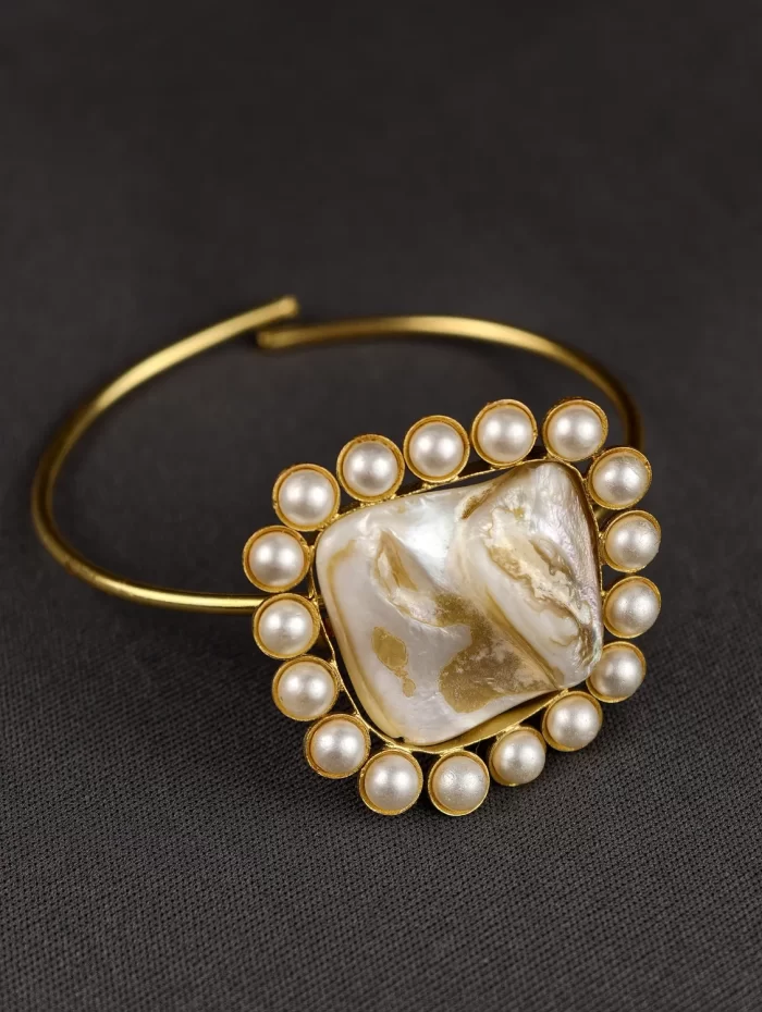 ROYAL STONE AND PEARL CLUSTER BANGLE Royal Stone and Pearl Cluster Bangle with an organic pearl-like centre and surrounding pearl halo