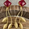 Ruby Stem and Leaf Statement Earrings displayed with textured gold-toned leaf drops