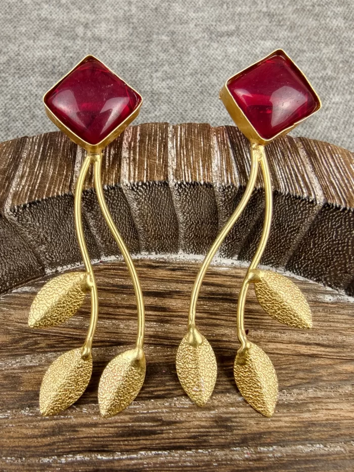 Ruby Stem and Leaf Statement Earrings displayed with textured gold-toned leaf drops