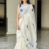 Shangupushpam Hand-Painted Saree – Front View Front view of Shangupushpam ivory saree with blue floral painting and silver border
