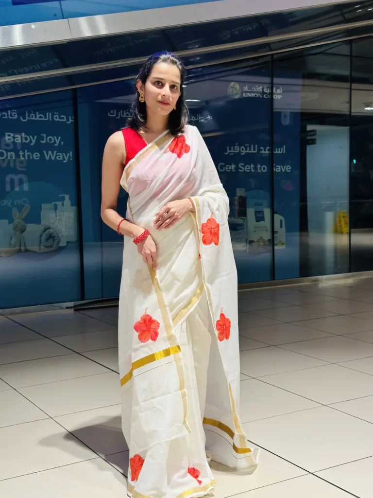 Chembarathi hand-painted saree in white with red hibiscus flowers and gold border – full-length front view