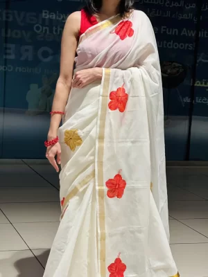 Close-up of Chembarathi white hand-painted saree with red hibiscus motifs and gold border