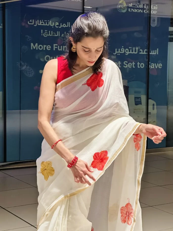 Chembarathi Hand-Painted Saree – Detail View Chembarathi hand-painted saree showing red hibiscus artwork and gold border detail