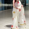 Chembarathi Hand-Painted Saree – Draped View Chembarathi white hand-painted saree with red hibiscus motifs and gold border – draped front view